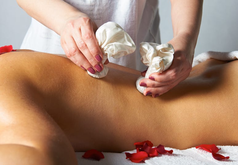 Eien Kräuterstempelmassage bei der Anwendung